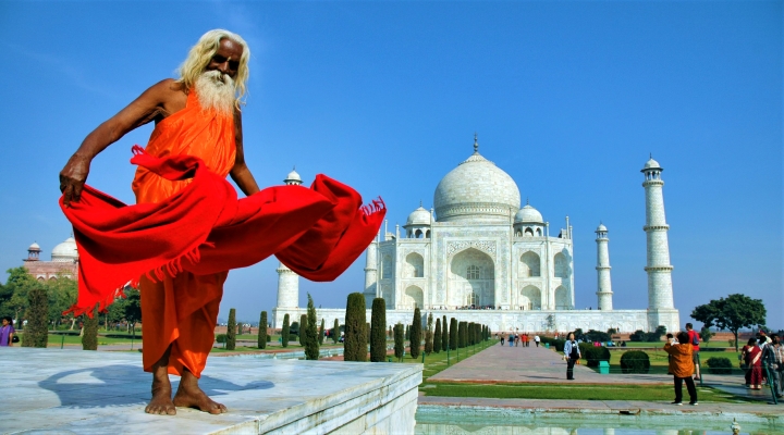 En man poserar framför Taj Mahal på en resa till Indien